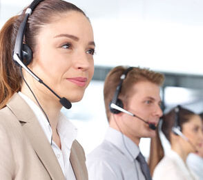 Drei Call Center Mitarbeiter mit Headsets